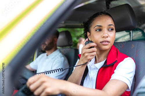 Photos Female paramedic using walkie-talkie radio in ambulance