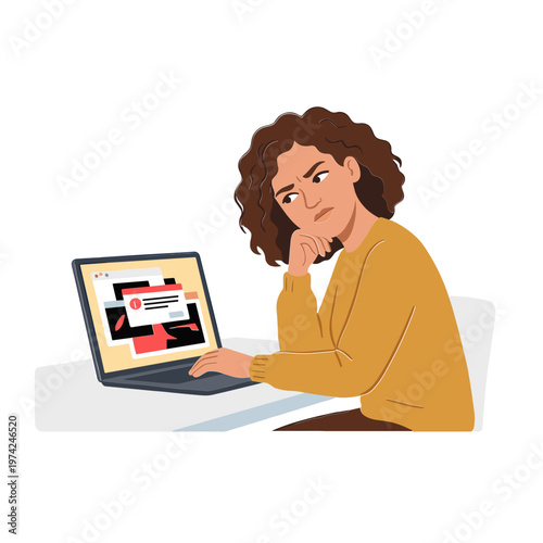 A woman sits at a desk looking concerned at her laptop screen.