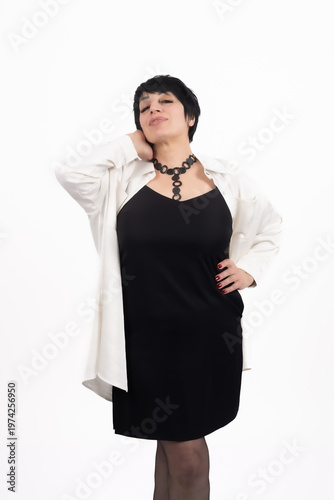 Confident woman in black dress and white shirt posing
