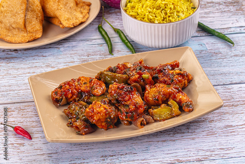 Plate of spicy glazed breaded prawn stir-fry with bell peppers and a side of yellow rice