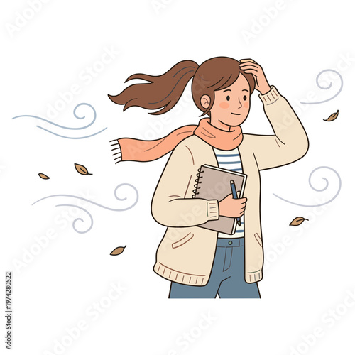 A woman holds books while shielding her face from the wind with her hand.