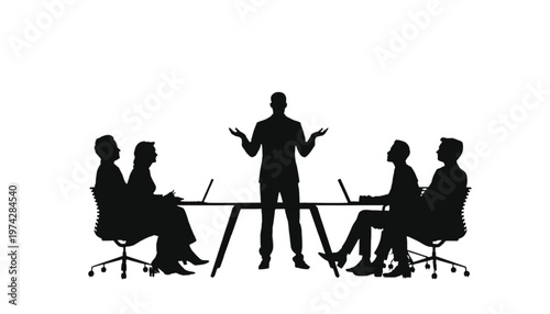 Speaker addressing a seated audience around a conference table with open gestures.