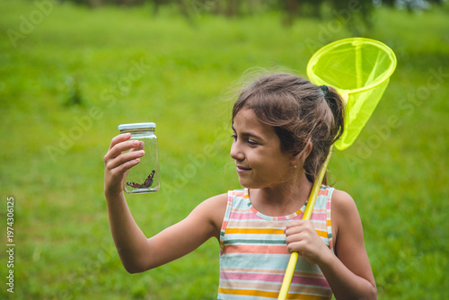 Canvas Print The child catches butterflies in nature. Selective focus. ,