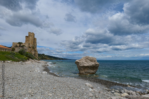 View of a beach with the tower of a medieval castle in Calabria, Italia.