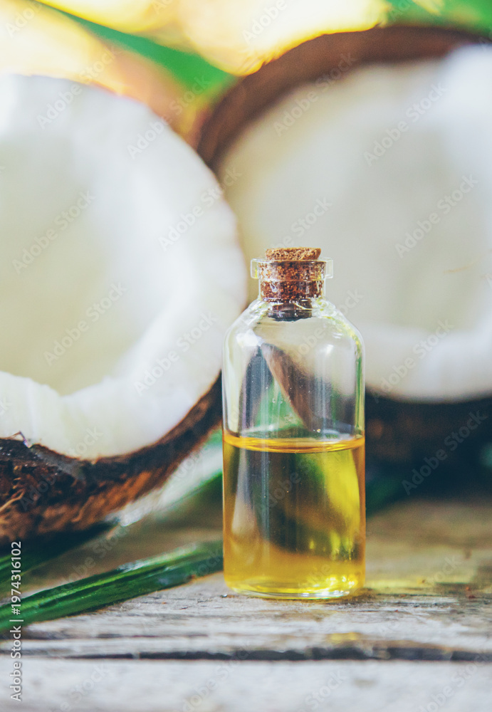 Fototapeta premium Natural coconut oil in a bottle. Selective focus.