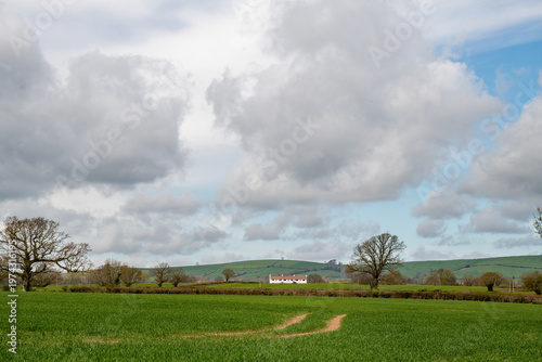 An English country walk with lush green fields and a rural landscape. Rambling, hiking and fresh air image. 