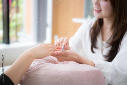 ネイルサロンで施術を行うネイリストの女性スタッフの丁寧な接客と美容サービスやカウンセリングのイメージ顔無し