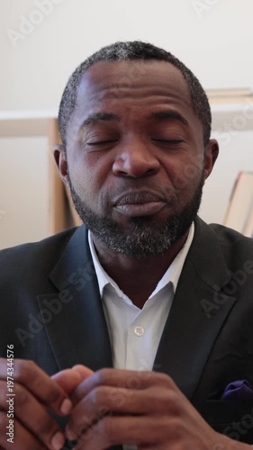 A thoughtful African American man in a suit speaks with conviction, his gaze directed away from the camera