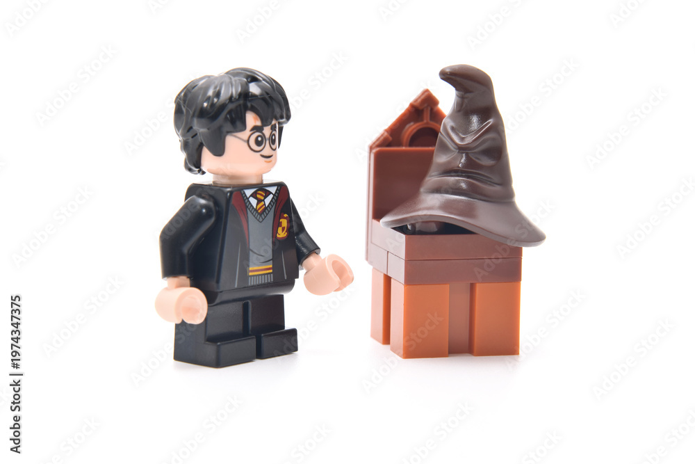 Obraz premium Lego minifigure of Harry Potter and speaking hat on a brown chair. Editorial illustrative image of famous fantasy
