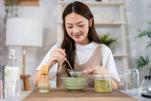 Photography Asian young woman preparing matcha by stirring green tea powder in bowl