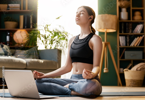Young Woman Meditating at Home with Laptop ? Mindfulness and Wellness Lifestyle
