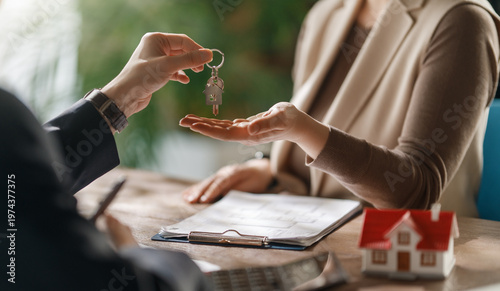 Obraz na plátně Real Estate Agent Handing Over House Keys to New Homeowner After Successful Purc
