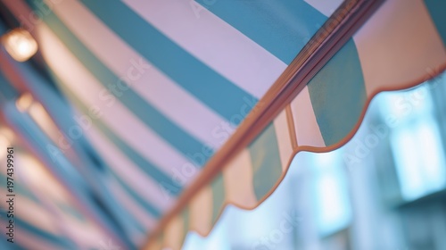 Striped retractable awning over cafe window. Sunshade canopy with blue and white pattern for protection against weather. Exterior shade structure for shop, restaurant or terrace design.