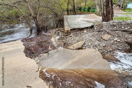 A collapsed bridge over a river after a strong flood