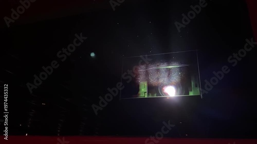 Video of a cinema projector operating inside a movie theater projection room. Light beam shining through the dark hall concept footage.