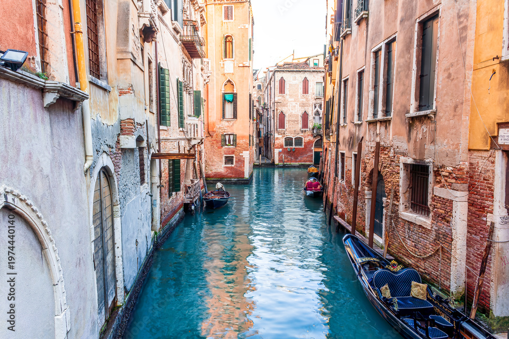 Obraz premium romantic view of a canal in Venice with boats and blue water and beautiful vintage buildings around the cityscape