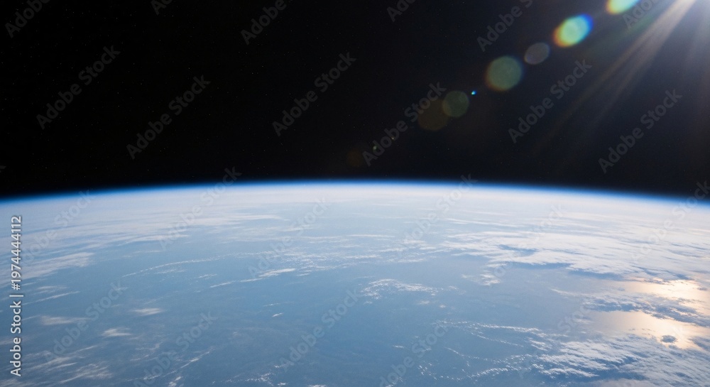 Fototapeta premium Earth seen from space with sun glare and clouds.