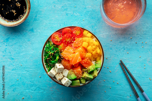 Salmon poke bowl with mango, avocado, tofu, wakame, overhead shot