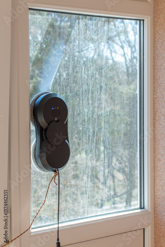 Black Vacuum Window Cleaning Robot on a Dirty  Window Surface