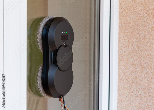 Black Vacuum Window Cleaning Robot on a Dirty  Window Surface
