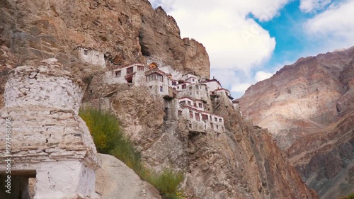 View of the Phugtal monastery built inside the mountain cave at Zanskar, Ladakh, India. Remote monastery in India. Clouds in sky during summer day. Travel and holidays concept.