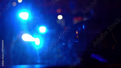 Police patrol car with flashing red and white emergency lights at night. Visible 