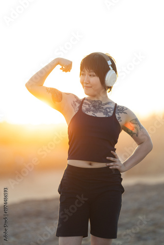 Young woman flexing arm demonstrating strength and confidence