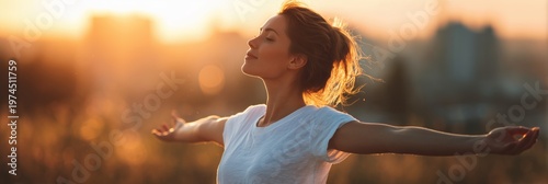 A woman with her arms outstretched, enjoying the fresh air and sunshine on a summer day, in a panoramic banner.