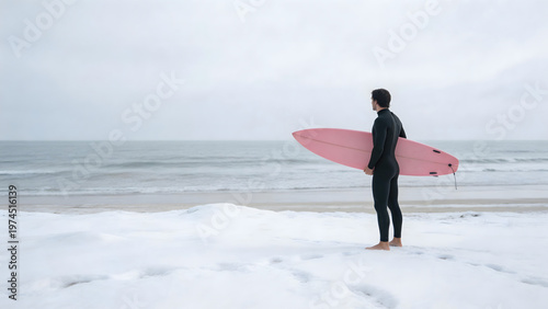 Surfer with pink board on snowy beach