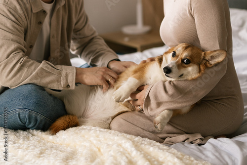 Couple cuddles small dog on bed in cozy bedroom with soft light and warm atmosphere