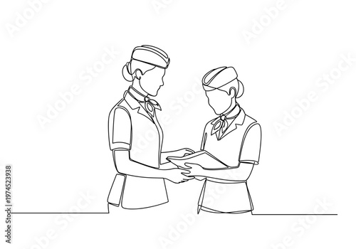 Two flight attendants discussing documents in airplane cabin
