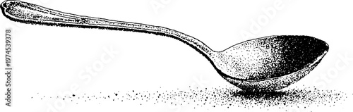 Long handled spoon resting on white surface with granules