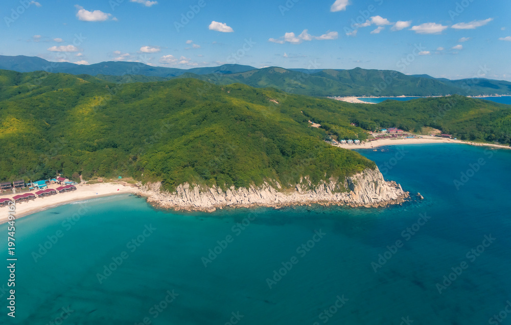 Obraz premium Aerial view shows a tranquil bay with white sand beaches meeting clear turquoise ocean water.