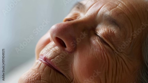Close-up of a serene elderly woman with closed eyes, embodying peace and contentment in a tranquil setting. A moment of relaxation and inner calm