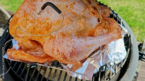 Large turkey roasting in kamado grill with temperature probes inserted, BBQ cooking process, outdoor grilling, meat preparation, thermometer control. 4K video footage of grilling process