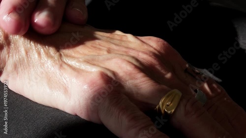 Extreme close up of senior hands applying moisturizing lotion. Focus on wrinkled skin texture and veins, representing dermatology, aging care, and daily hydration routine for the elderly