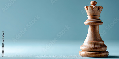 Wooden chess queen on a soft blue background, minimal studio still life with copy space.
