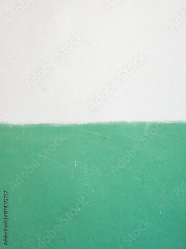 White and green painted wall surface with rough texture