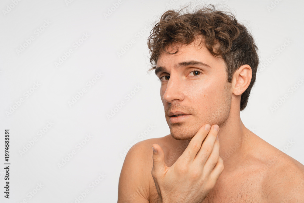 Fototapeta premium Caucasian man, skincare and washing face for grooming, hygiene and hydration in studio. Happy, male person and smile with cleaning or facial treatment for wellness and beauty on white background