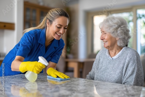Friendly Caregiver Cleaning a Kitchen Counter for a Senior Woman
