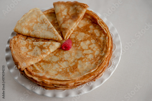 Round homemade crepe cake with sliced piece. 