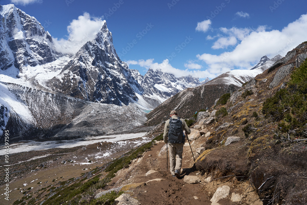 Fototapeta premium Hiker with backpack of Trekking on Trail Everest Base Camp surrounded by Himalayan Mountains snowy peaks and Glacier. Nepal.