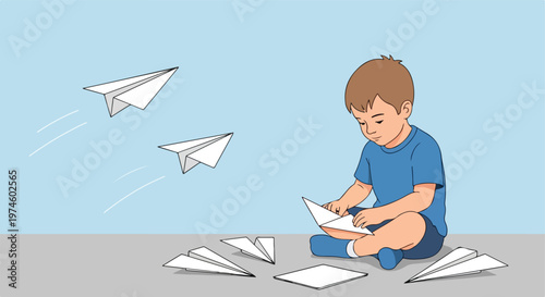 A young boy sits on the floor folding paper into various flying paper airplanes