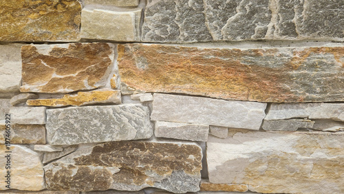 Natural stacked stone wall texture with mixed earthy tones, perfect for architectural backgrounds, exterior design, and rustic modern concepts.