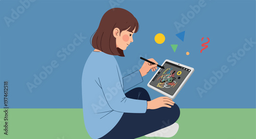 A young woman sitting and drawing on a digital tablet with a stylus pen