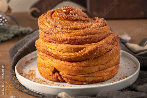 Obraz na płótnie Freshly Baked Cinnamon Roll Cruffin with Sugar Topping on a Ceramic Plate
