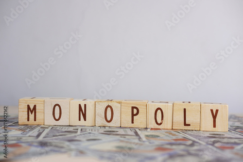 The word MONOPOLY written on scattered dollars. The concept of trade monopoly. Economic control, capitalism, business strategy, or power concentration in modern economics.
