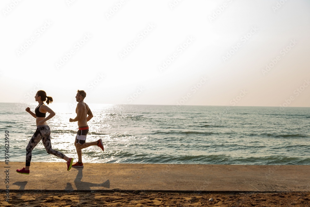 Fototapeta premium Couple jogging along oceanfront photo