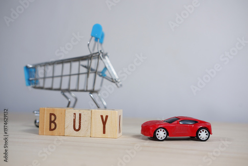 Car buying concept (miniature car and the word BUY)
