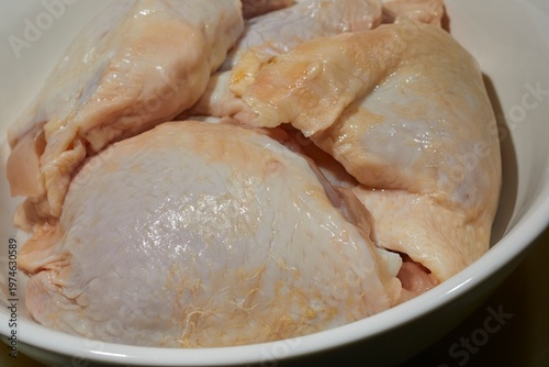 Raw, bone-in, skin-on, chicken thighs
